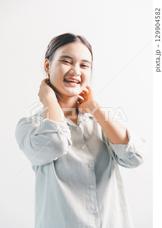 Asian woman rejoicing, looking happy, champion, fist pump gesture, standing over white background. young woman had happy, positive expression on her face, highlighted by bright smile. 129904582