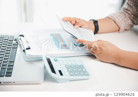 Business hands holding saving account passbook with calculator, account and saving concept. finance effectively, calculate income, track each bill and payment, accounting for bank statements and tax. Business hands holding saving account passbook with calculator, account and saving concept. finance effectively, calculate income, track each bill and payment, accounting for bank statements and tax. 129904628