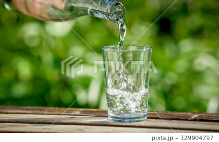water pouring into glass water pouring into glass 129904797