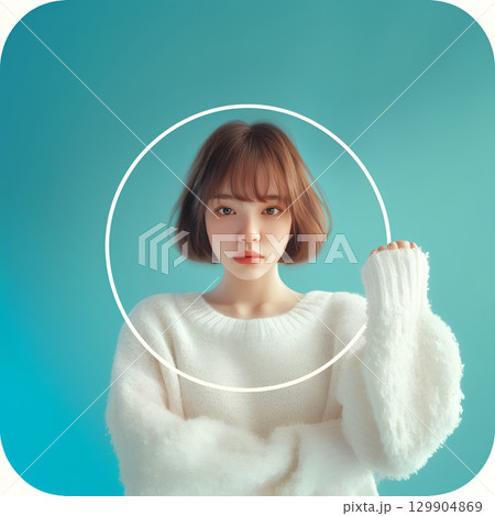壁を背景に立つ白いニットの女性 129904869