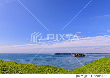 青空の下、浜中町アゼチの岬から望む嶮暮帰島と太平洋の風景  129905157
