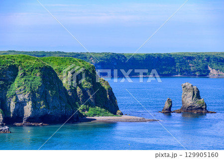 青空の下、浜中町アゼチの岬から望む嶮暮帰島と太平洋の風景  129905160