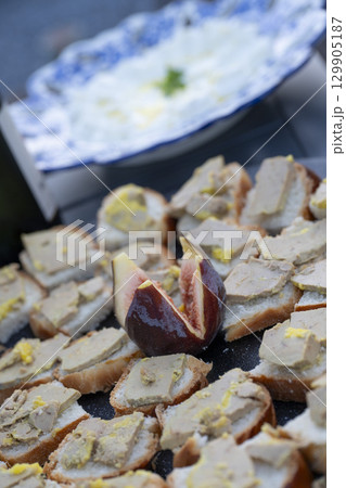 Foie gras and fig toast served as a delightful aperitif in an outdoor setting during a sunny Foie gras and fig toast served as a delightful aperitif in an outdoor setting during a sunny 129905187