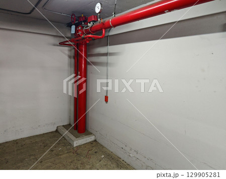Red Fire Pump System in Empty Basement Industrial Space Red Fire Pump System in Empty Basement Industrial Space 129905281