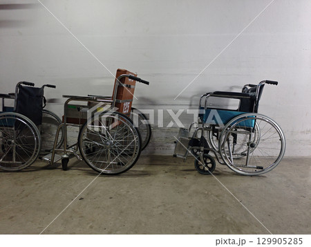 Wheelchairs Positioned Against Wall in Indoor Storage Area Wheelchairs Positioned Against Wall in Indoor Storage Area 129905285
