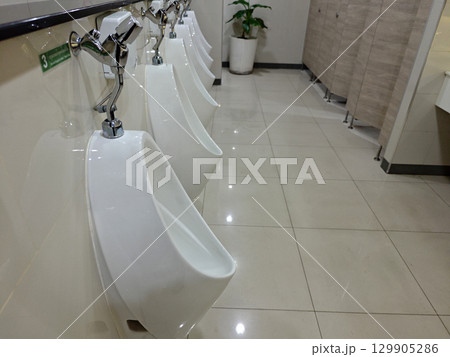 Modern and Clean Male Restroom with White Urinals and Tiles 129905286