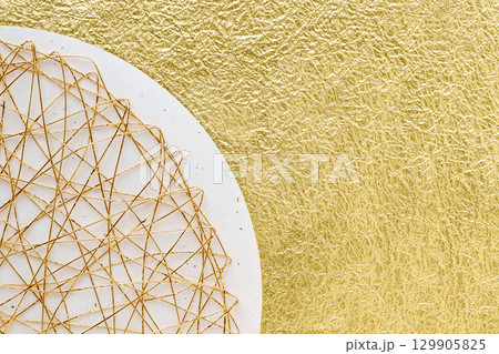 金色のもみ和紙と水引の和風背景 金色のもみ和紙と水引の和風背景 129905825
