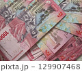 A Rich Tapestry of Indonesian Rupiah 100000 Banknotes with Cultural Motifs. 129907468
