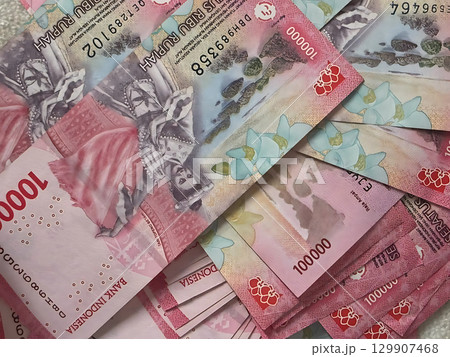 A Rich Tapestry of Indonesian Rupiah 100000 Banknotes with Cultural Motifs. 129907468