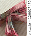 Flowing Wave of Indonesian Rupiah A Thick Stack of 100000 Banknotes. 129907470