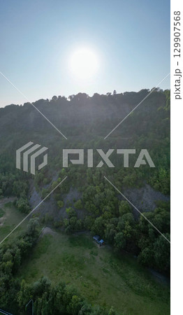 A Beautiful and Serene Landscape Captured at Sunset, Featuring Lush Greenery and Rolling Hills 129907568