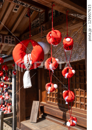 Sarubobo dolls at Hida Kokubun-ji Temple in Takayama, Japan Sarubobo dolls at Hida Kokubun-ji Temple in Takayama, Japan 129907615