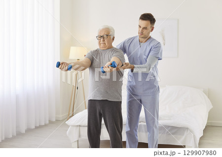 Senior man rehabilitation exercise with dumbbells, spinal therapy for aged man at home, supporting Senior man rehabilitation exercise with dumbbells, spinal therapy for aged man at home, supporting 129907980