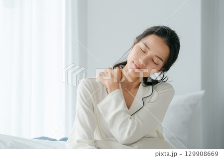 寝起きで肩を揉む女性 129908669
