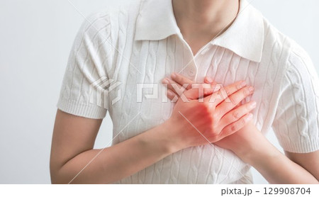 Heart failure. young woman pressing on chest with painful expression. Severe heartache, having heart attack or painful cramps, heart disease. people with heart problem concept. 129908704