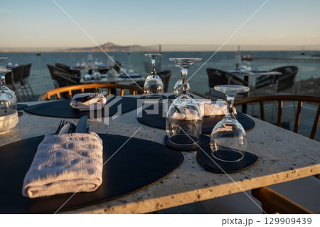 An inviting beachfront restaurant with beautifully arranged tables 129909439