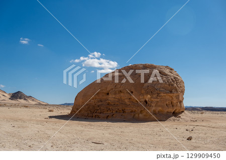 Enormous rock formation in the Sinai desert showcasing the stark beauty of Egypts natural landscape under a clear blue sky Enormous rock formation in the Sinai desert showcasing the stark beauty of Egypts natural landscape under a clear blue sky 129909450