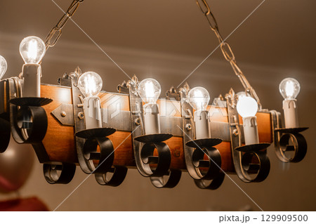 Industrial style ceiling light fixture with multiple bulbs illuminating a cozy interior space Industrial style ceiling light fixture with multiple bulbs illuminating a cozy interior space 129909500