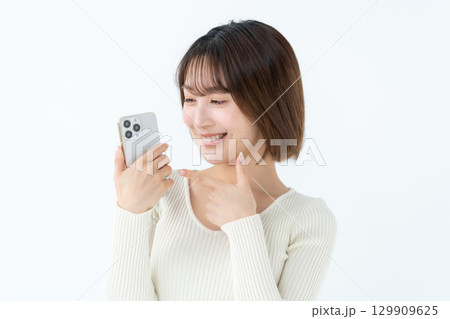 若い女性　カジュアル　スマホ　指差し 129909625