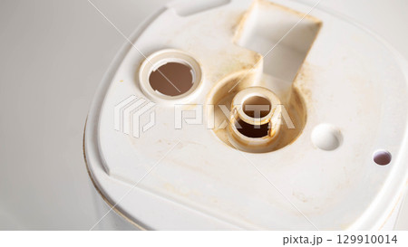 Unpleasant smell, rust and scale from water in the humidifier, white background, close-up 129910014