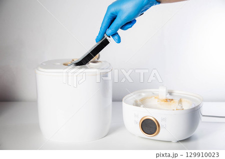 Cleaning the humidifier from scale, rust and unpleasant odors with a special brush and chemical agent. Service, close-up. Copy space for text 129910023