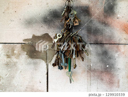 bunch of metal keys against concrete wall, close-up 129910339