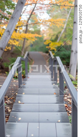 Gray Stone Stairs Ascending Through Autumn Trees in Soft Focus Background 129910750