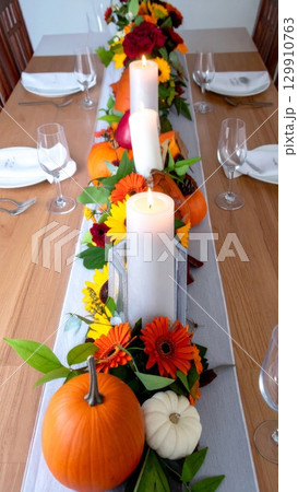 Festive Autumnal Table Centerpiece with Pumpkins Candles and Floral Arrangement 129910763