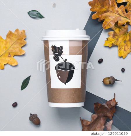 Takeaway Coffee Cup with Acorn Graphic and Fall Leaves on Striped Gray Surface 129911039