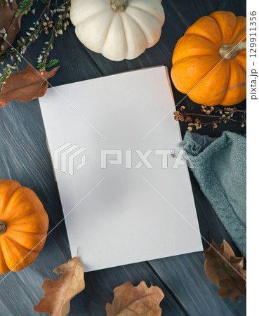 Autumn Still Life with Pumpkins and Blank Paper on Dark Wood Table 129911356