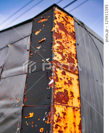 Abstract Metal Corner with Rust and Peeling Paint under Blue Sky Abstract Metal Corner with Rust and Peeling Paint under Blue Sky 129911395