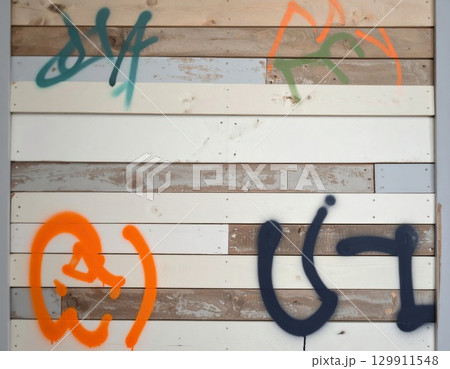 Graffiti Art on a Weathered Wood Wall with Layers of Colorful Spray Paint Graffiti Art on a Weathered Wood Wall with Layers of Colorful Spray Paint 129911548