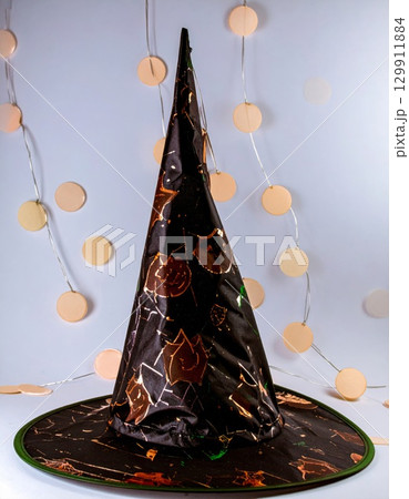 Sparkling Witch Hat with Golden Accents on a White Background for Halloween 129911884
