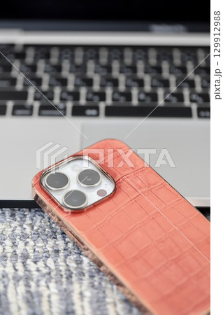 ノートパソコンのキーボードの前に置いたスマホ ノートパソコンのキーボードの前に置いたスマホ 129912988