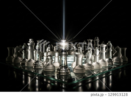 Glass chess set with a glowing king in the center symbolizing leadership and strategy 129913128