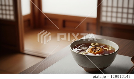 Traditional korean sujeonggwa, a cold cinnamon punch with dried persimmon and pine nuts 129913142