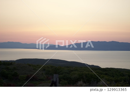 朝日と山並みのシルエット風景 129913365