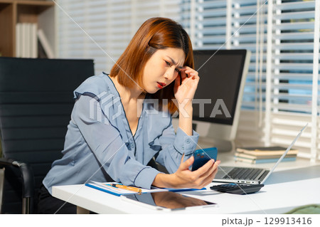 Stress businesswoman is sitting at table, under stress from working 129913416