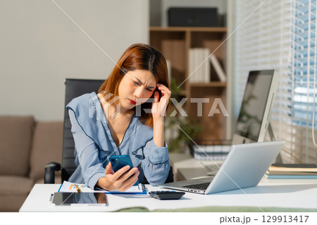 Stress businesswoman is sitting at table, under stress from working 129913417