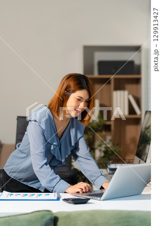 Businesswomen working with smart phone and laptop and digital tablet computer in office. 129913427