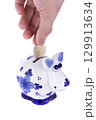 Piggy bank in a shape of a cow with blue ornament, coin falling 129913634