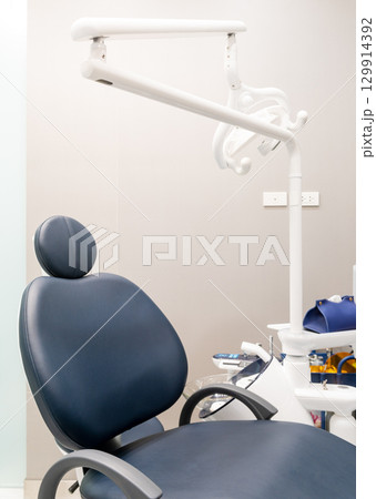 Vertical view of modern blue dentist chair with lamp Vertical view of modern blue dentist chair with lamp 129914392