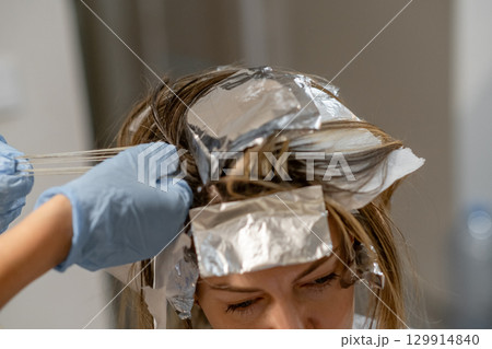 Hair coloring process with foils in a salon setting during daylight hours Hair coloring process with foils in a salon setting during daylight hours 129914840
