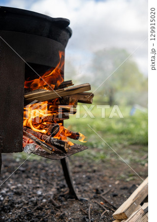 Cooking Over an Open Fire With Flames and Logs in a Natural Outdoor Setting During Daytime Cooking Over an Open Fire With Flames and Logs in a Natural Outdoor Setting During Daytime 129915020