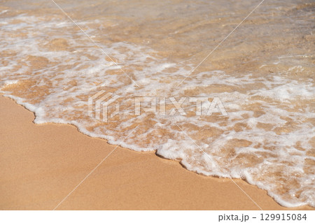 Waves gently lapping on the sandy shore of an Egyptian beach during sunset, creating a serene atmosphere Waves gently lapping on the sandy shore of an Egyptian beach during sunset, creating a serene atmosphere 129915084