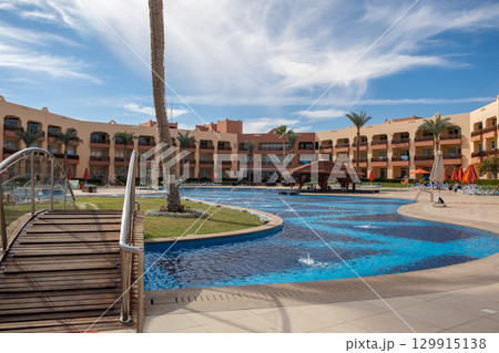 Luxurious resort in Egypt featuring expansive swimming pool and palm trees 129915138