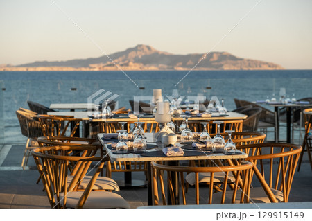 A cozy yet elegant oceanfront dining experience, with set tables and glassware A cozy yet elegant oceanfront dining experience, with set tables and glassware 129915149