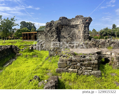 Fortress ruins with green grass and blue sky with white clouds 129915322