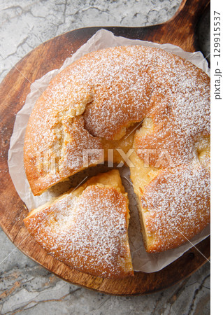 Torta Nua is an exquisite custard cake, perfect for breakfast or as a snack closeup on the wooden board on the table. Vertical top view 129915537