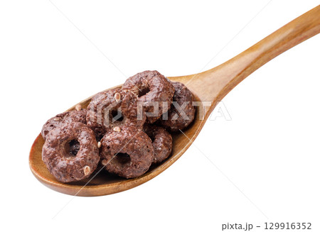 Chocolate corn rings in a wooden spoon on a white background. Isolated Chocolate corn rings in a wooden spoon on a white background. Isolated 129916352